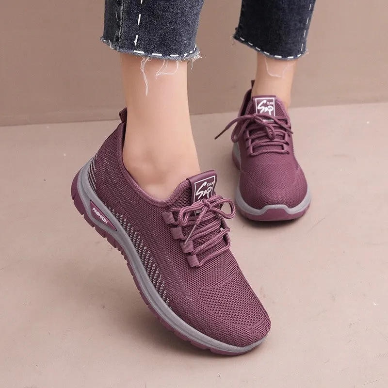 Women's black mesh sneakers with round toe and cross strap detail on rubber sole