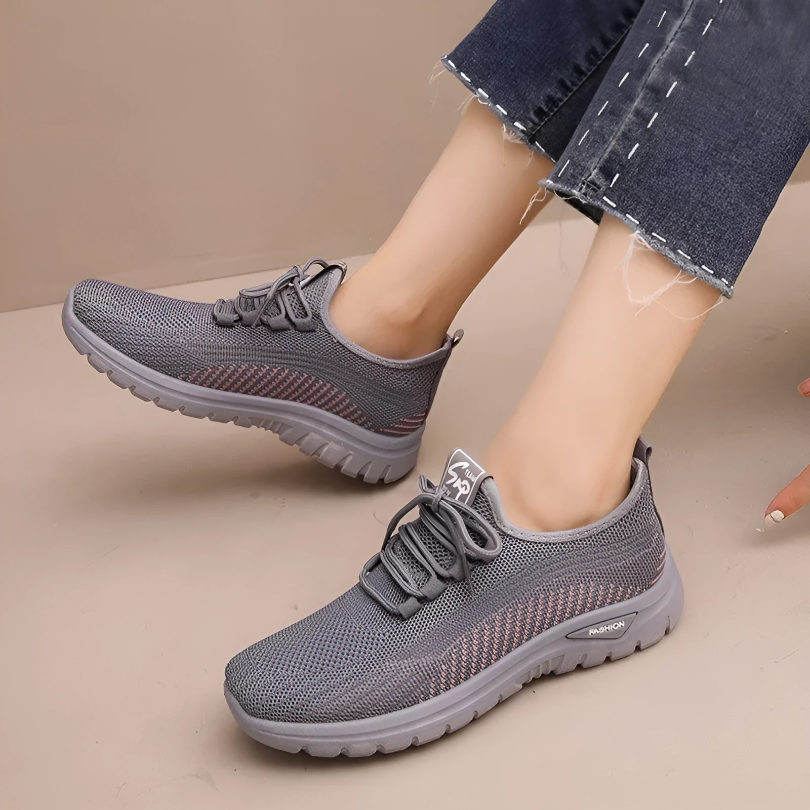 Women's black mesh sneakers with round toe and cross strap detail on rubber sole