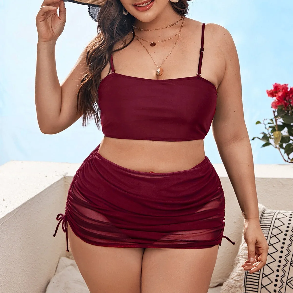 Women's solid colour mesh bikini three-piece set with apron on a mannequin.