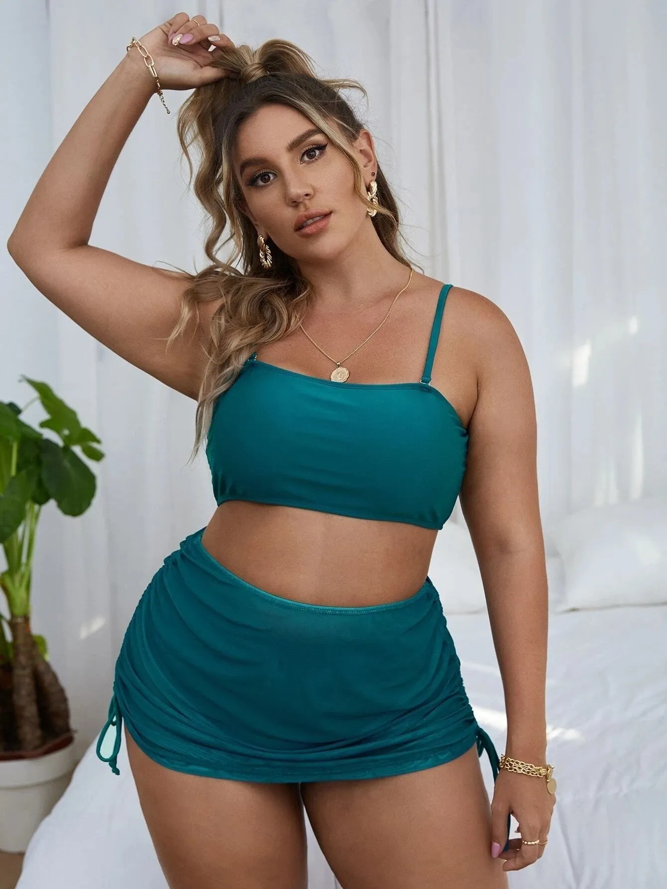 Women's solid colour mesh bikini three-piece set with apron on a mannequin.