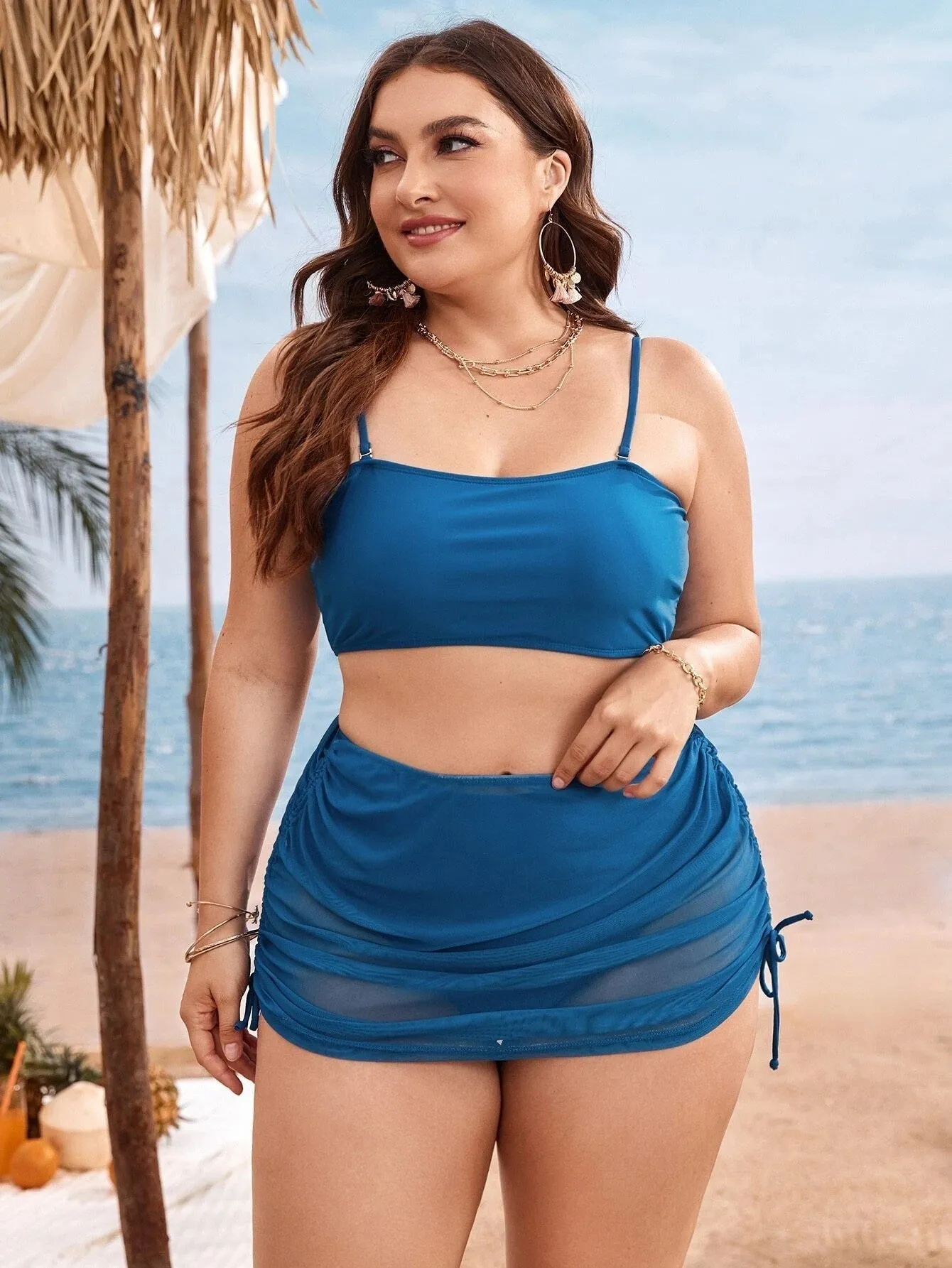 Women's solid colour mesh bikini three-piece set with apron on a mannequin.