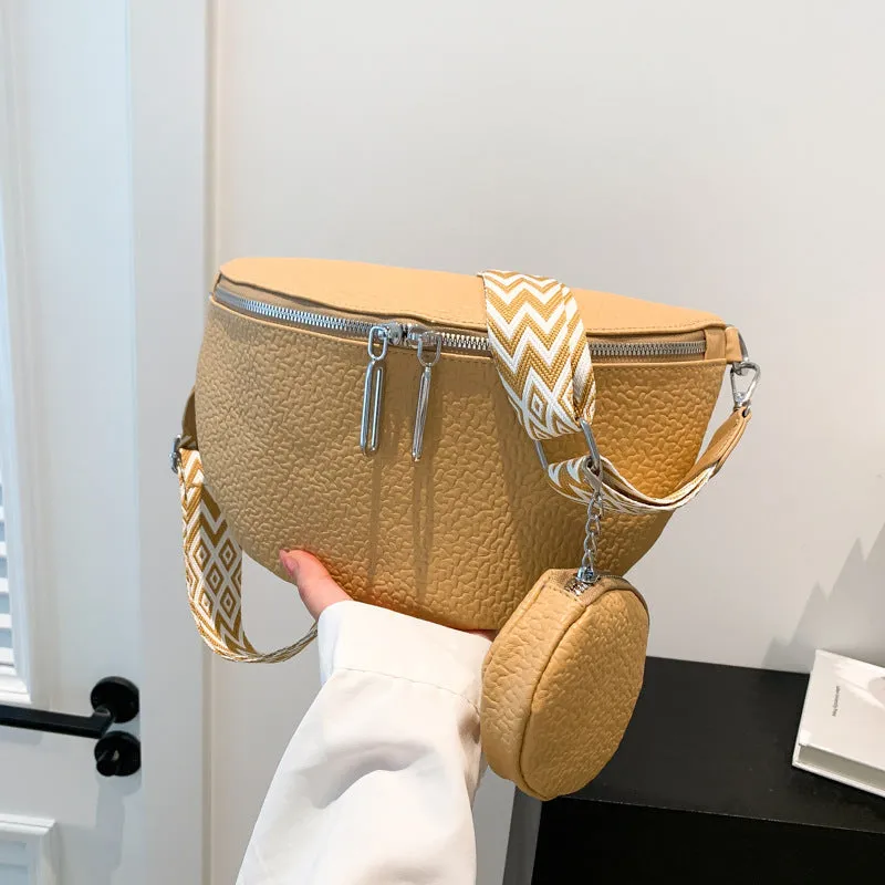 Solid colour women's crossbody bag with saddle lock zipper texture in a horizontal square clamshell shape.