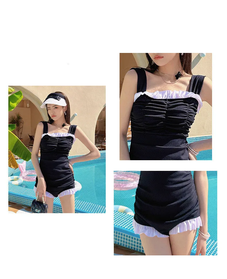 Women's solid colour one-piece jumpsuit swimsuit with suspender straps on a hanger.