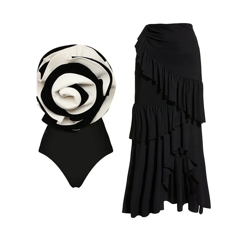 Women's black and white one-piece swimsuit with matching skirt cover-up on beach
