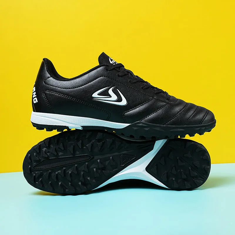 Low top football shoes with synthetic leather upper and rubber sole in black and white broken nails colour.