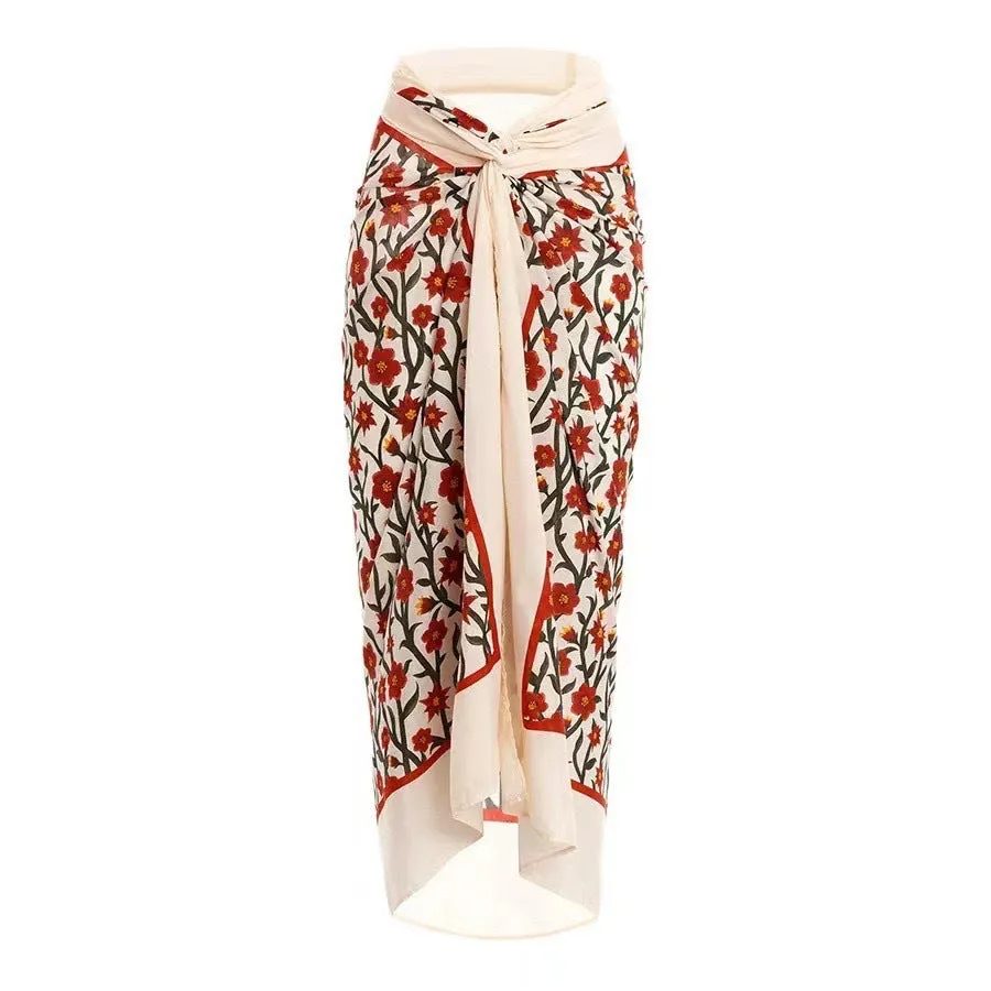 Female model wearing two-piece halter neck swimsuit with floral print and hollow-out gauze skirt cover-up