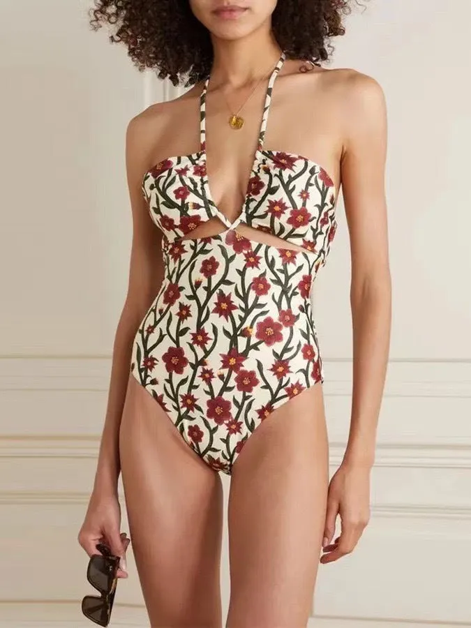 Female model wearing two-piece halter neck swimsuit with floral print and hollow-out gauze skirt cover-up