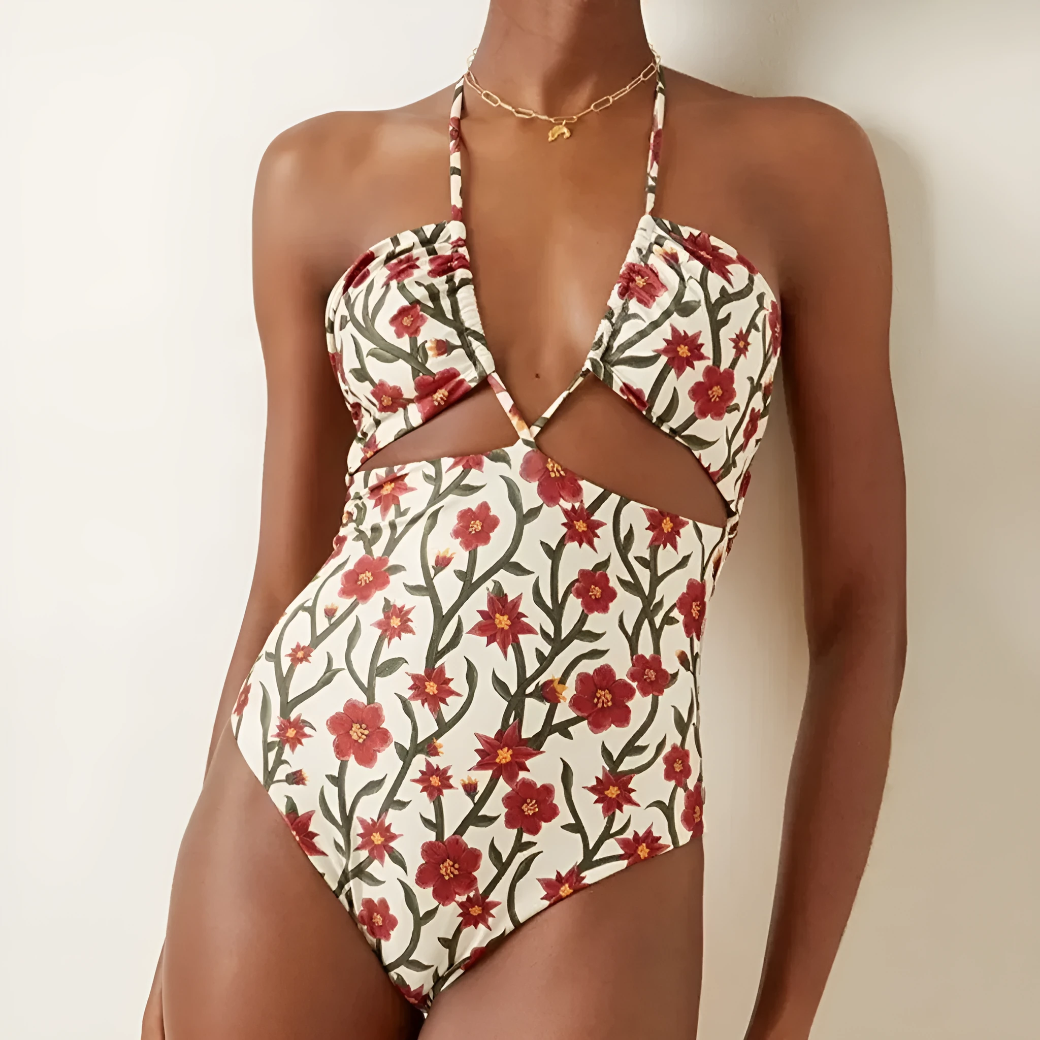 Female model wearing two-piece halter neck swimsuit with floral print and hollow-out gauze skirt cover-up