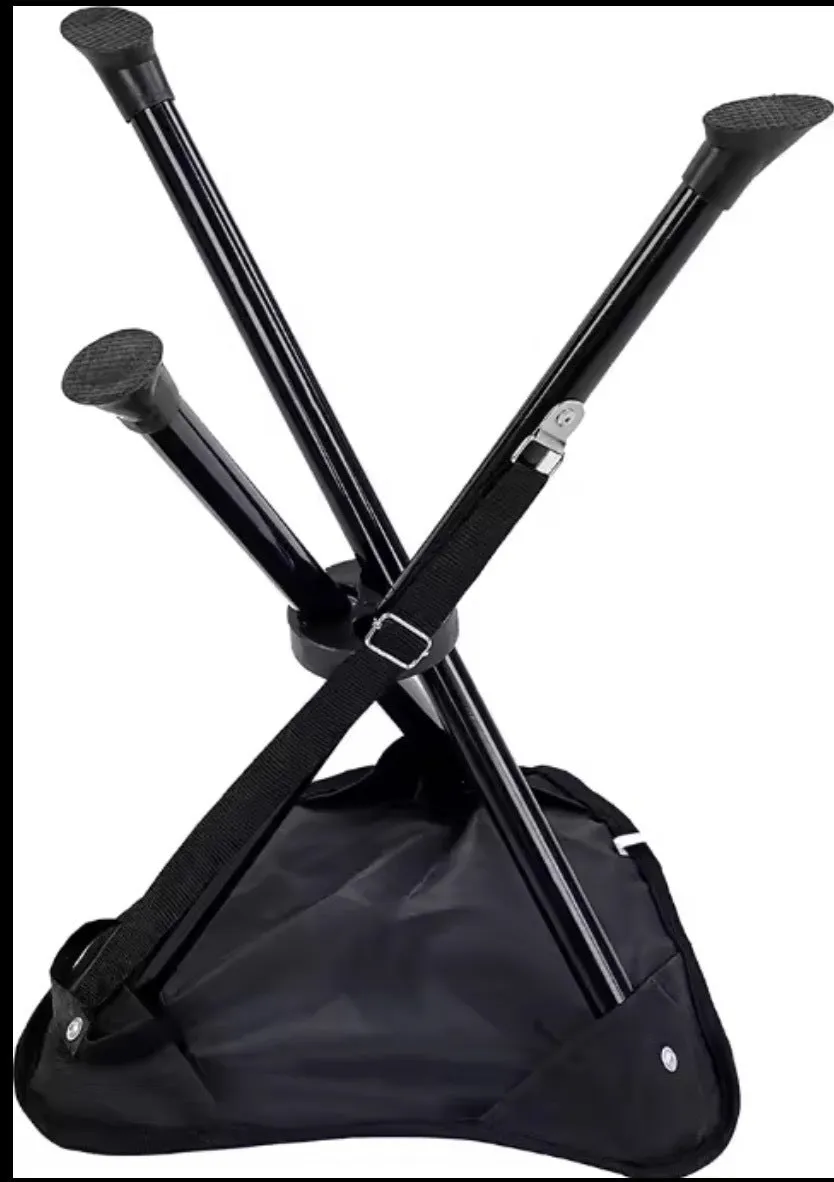 Green folding camping stool with aluminium tripod legs set up outdoors on grass