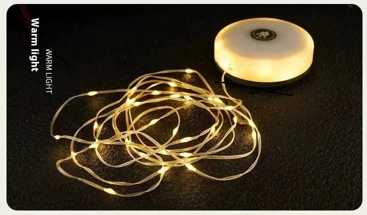 Charging multifunctional camping lantern with warm and colourful light modes on a campsite table