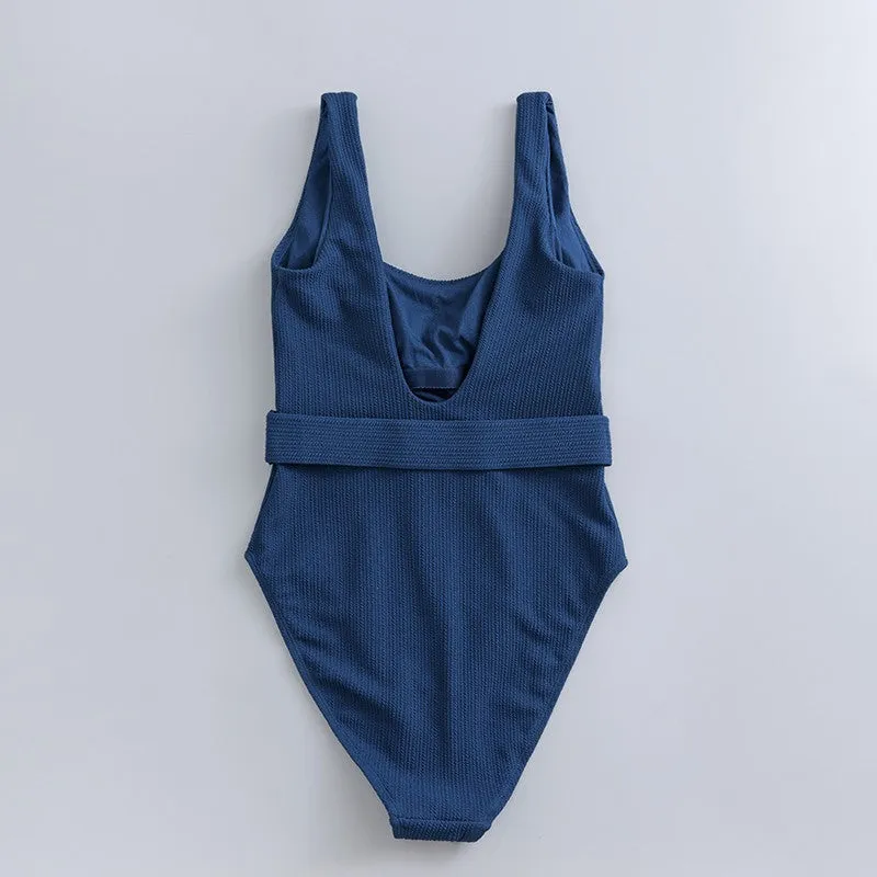 Navy blue one-piece women's swimsuit with a triangle neckline and slimming fit on a mannequin.