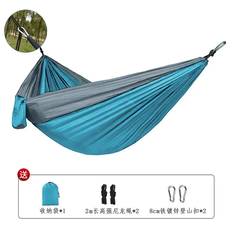 Blue nylon parachute cloth camping hammock hanging between two trees