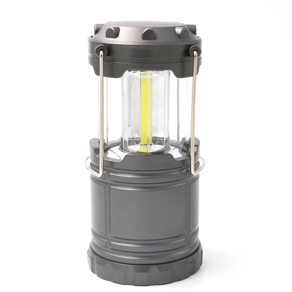 COB LED camping lamp in black with telescopic body and hook, standing on a wooden surface