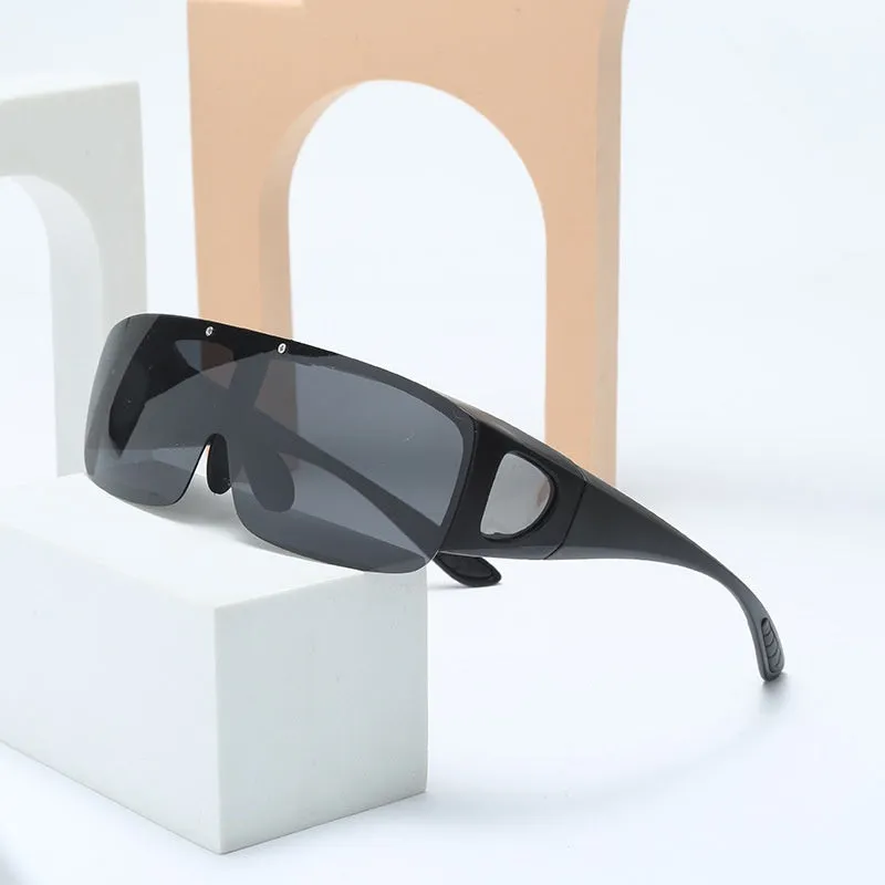 One-piece polarised sunglasses with myopia correction and multiple interchangeable coloured lens sheets laid out.