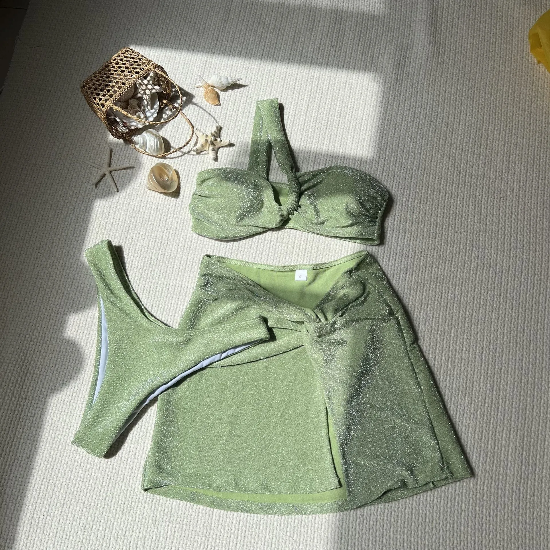 Women's one-shoulder tube top glossy polyester swimsuit three-piece set in light green, shown with pants and skirt