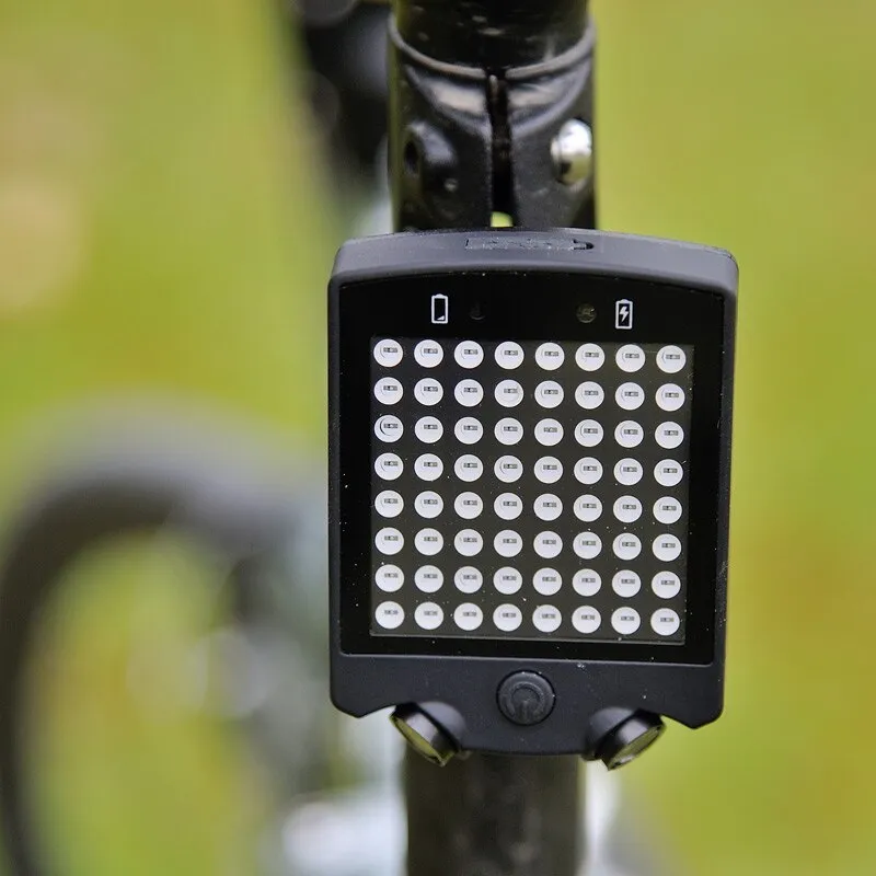 Black LED bicycle turn signal unit with dot matrix display and laser line, wireless remote control, on a bicycle seatpost