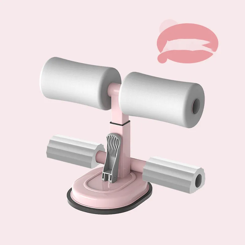 Pink adjustable sit-up bar floor assistant with foam pad and suction base on smooth floor