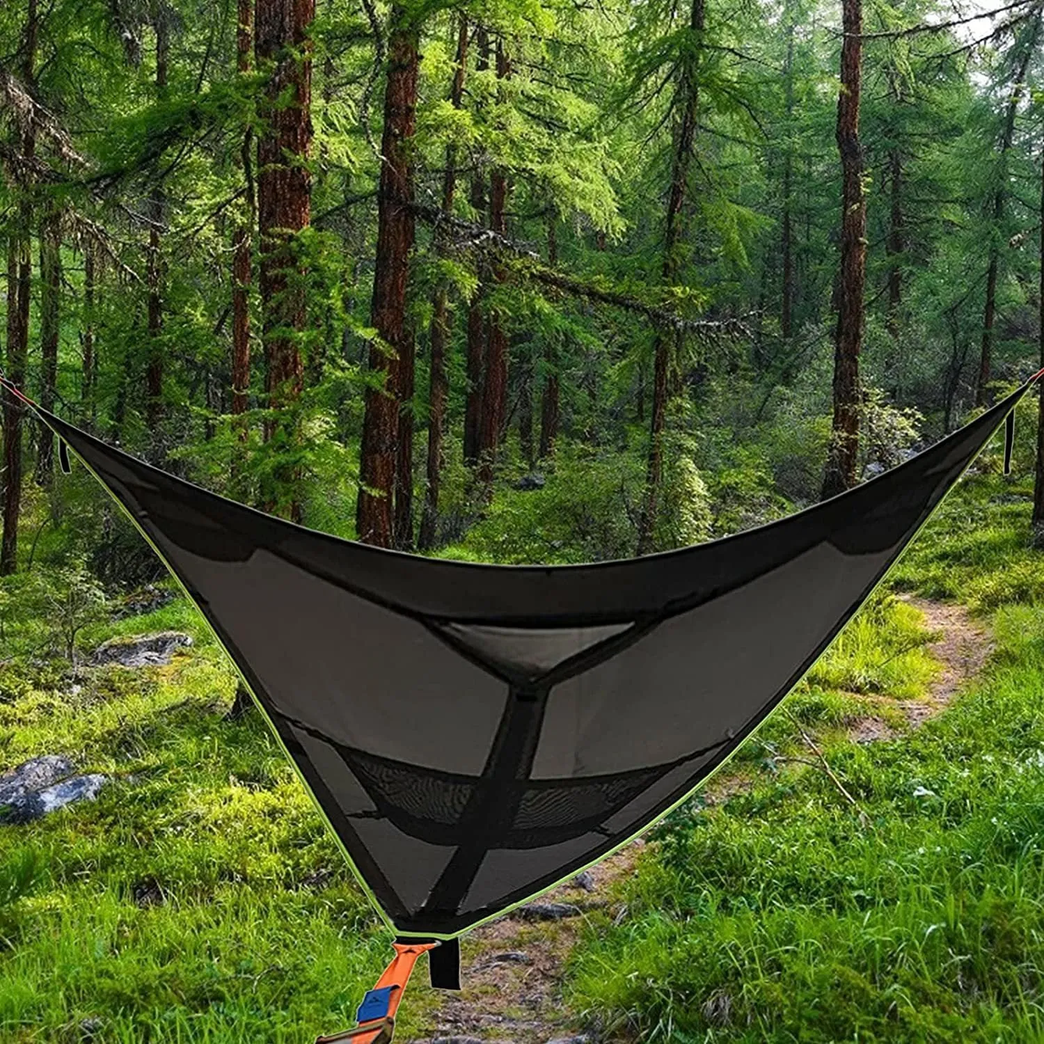 Black polyester portable multi-person triangle hammock lying on grass with trees in background