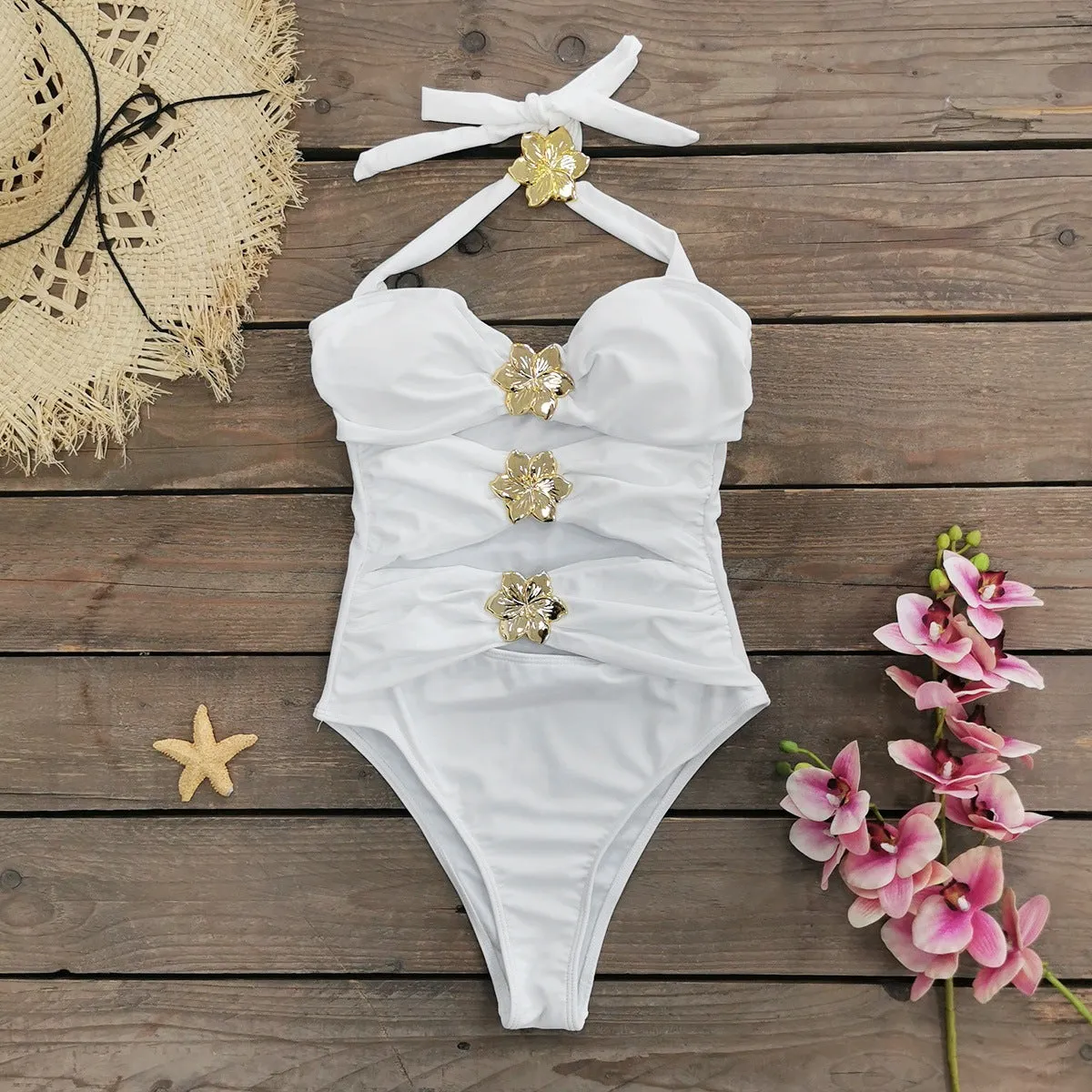 Women's black hollow-out tube top one-piece swimsuit with matching high-waist short skirt laid flat.