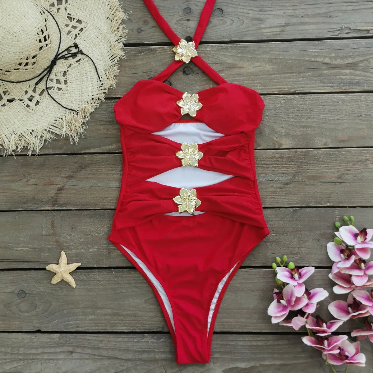 Women's black hollow-out tube top one-piece swimsuit with matching high-waist short skirt laid flat.