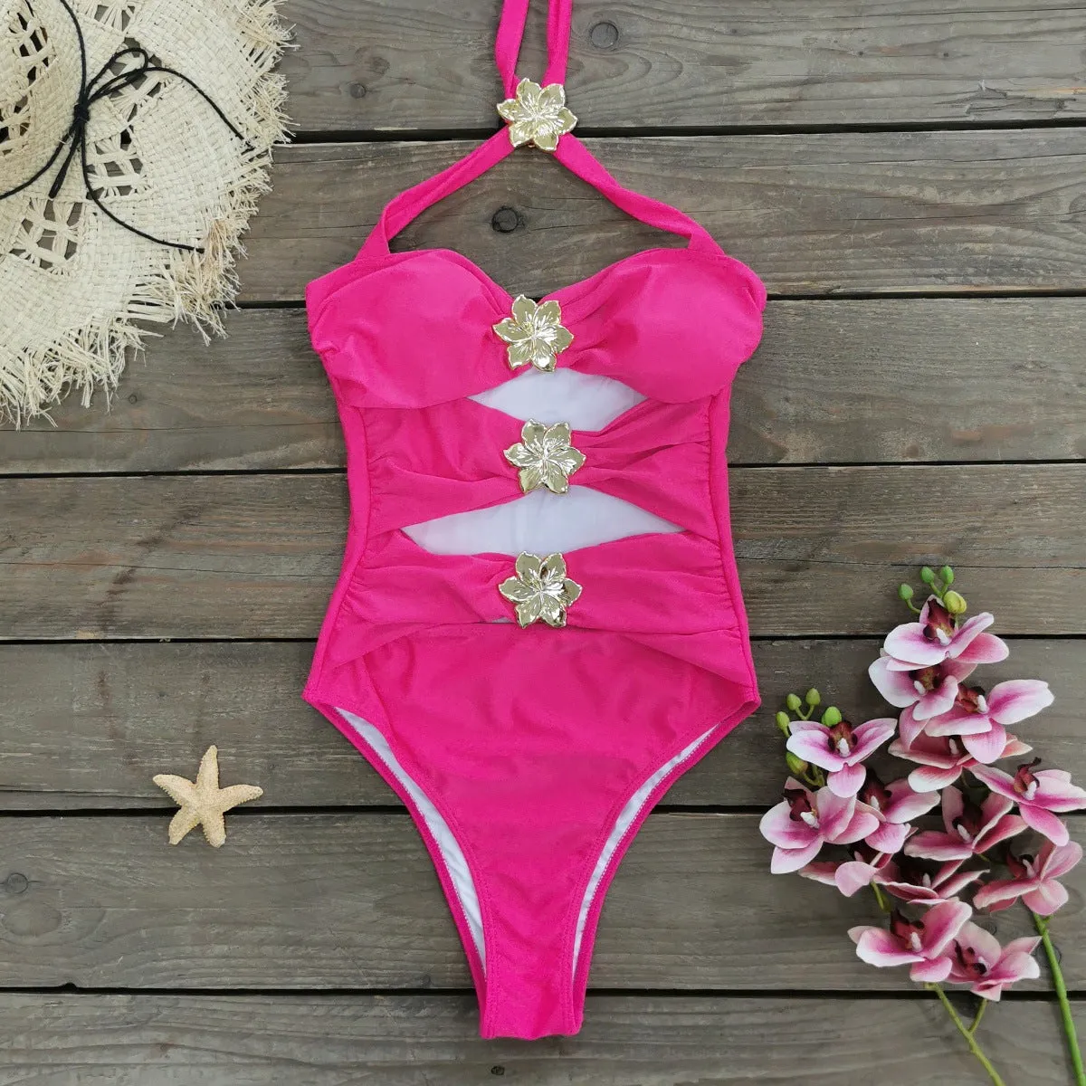 Women's black hollow-out tube top one-piece swimsuit with matching high-waist short skirt laid flat.