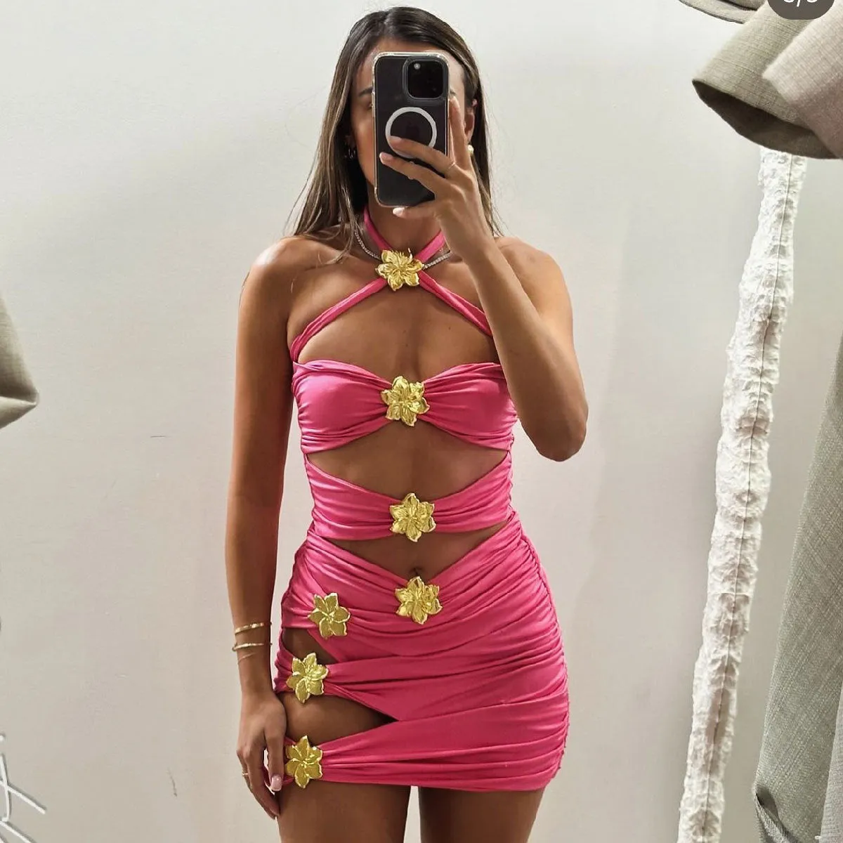 Women's black hollow-out tube top one-piece swimsuit with matching high-waist short skirt laid flat.