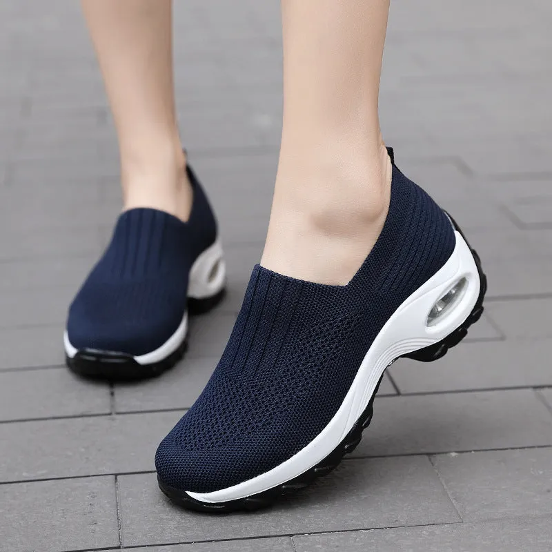 Women's mesh sports shoes in black, side view, showing breathable upper, thick bottom sole, and slip-on design