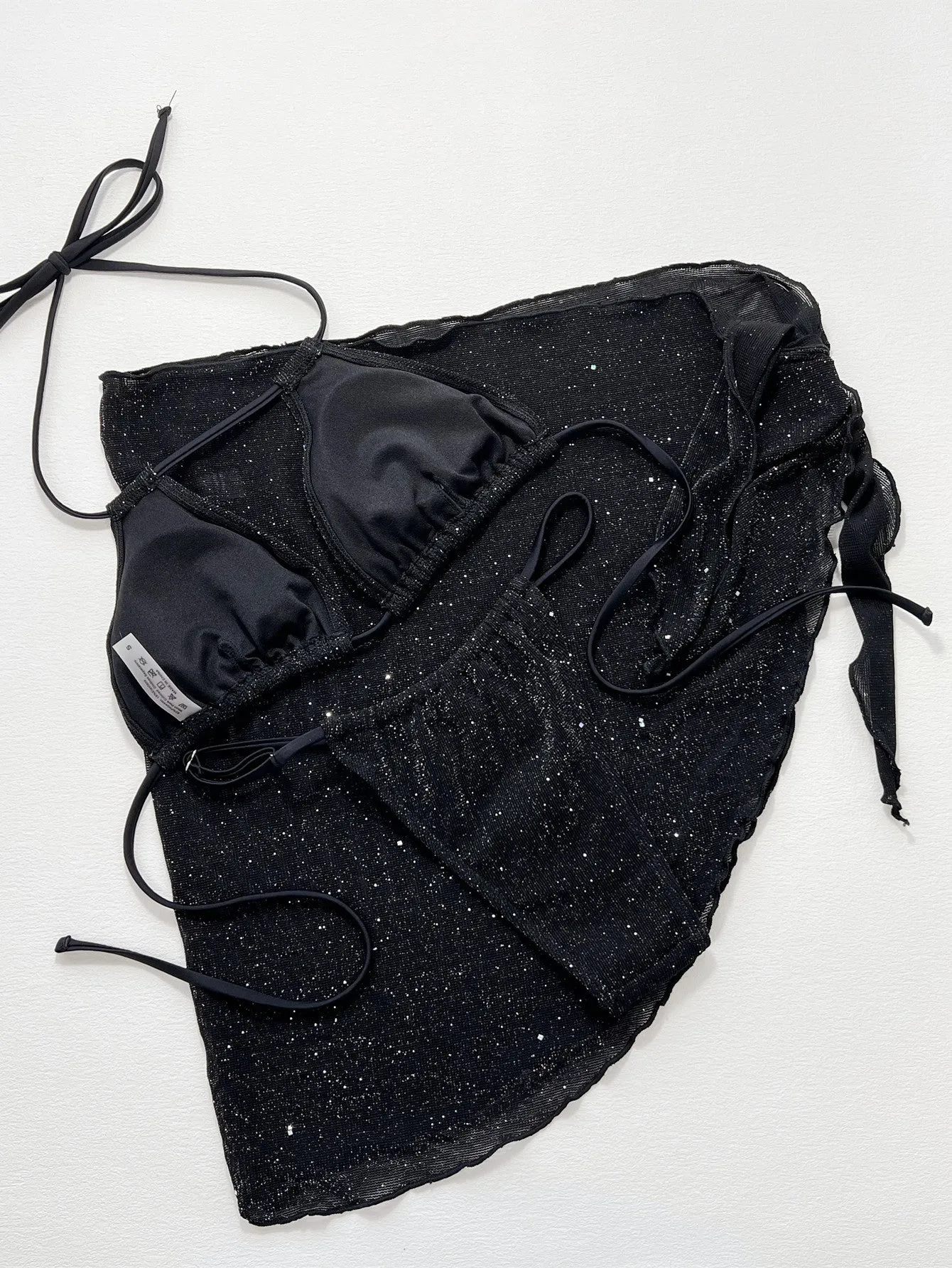 Black three-piece bikini swimsuit set with matching top and shorts on white background