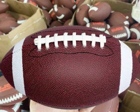 Machine sewn PU children's training American football in brown, shown with stitched seams and pointed ends for practice play