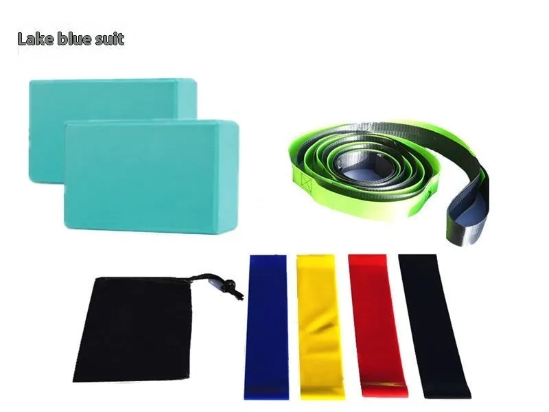 Yoga block eight-piece set with bricks, stretch belt, latex bands, and black storage bag on a floor.