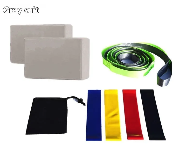 Yoga block eight-piece set with bricks, stretch belt, latex bands, and black storage bag on a floor.