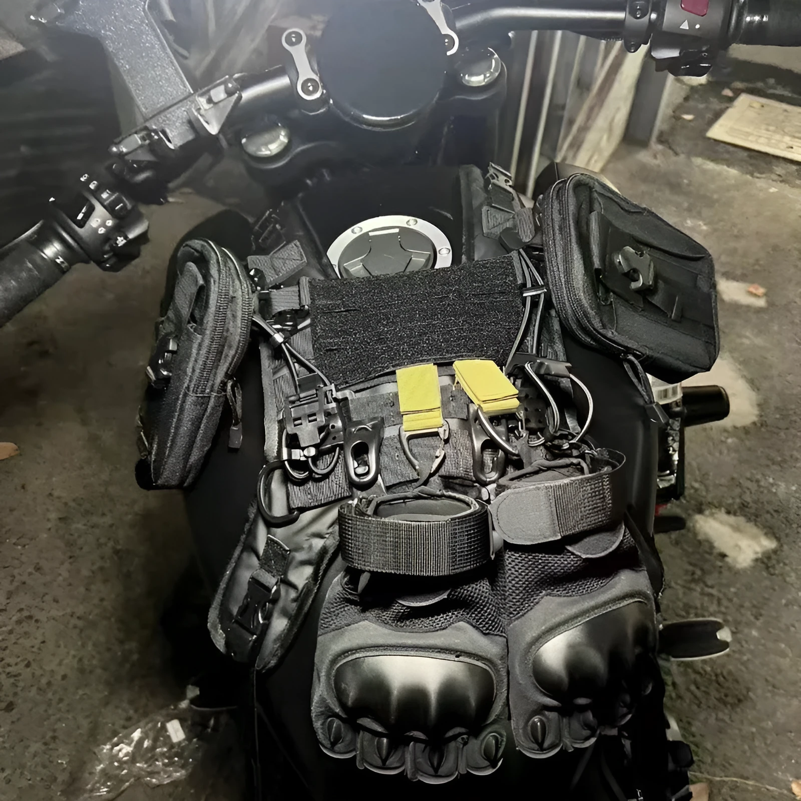 Universal black nylon motorcycle fuel tank bag mount base with adjustable straps on a black tank