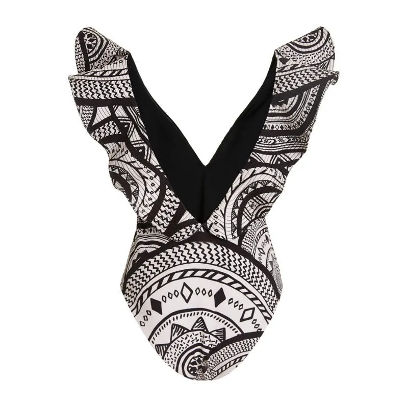Women's vintage printed deep V-neck one-piece swimsuit with a matching wrap skirt laid flat.