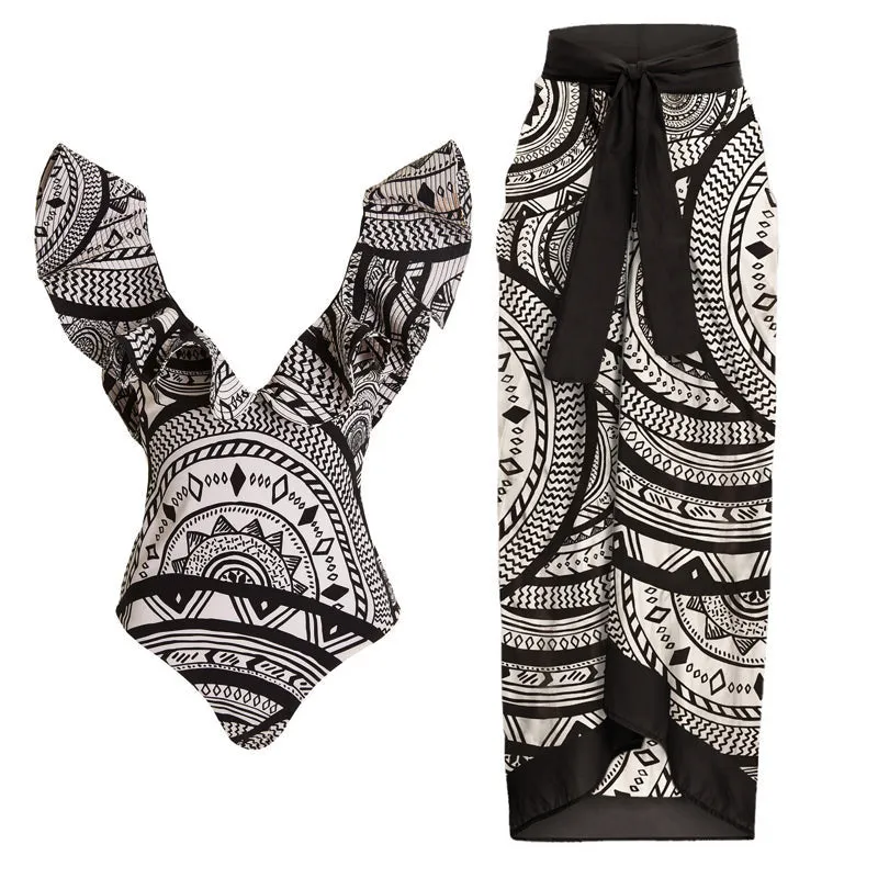 Women's vintage printed deep V-neck one-piece swimsuit with a matching wrap skirt laid flat.