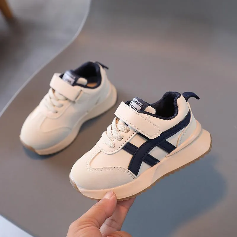 Children's solid-colour sneakers with Velcro strap closure and rubber sole.
