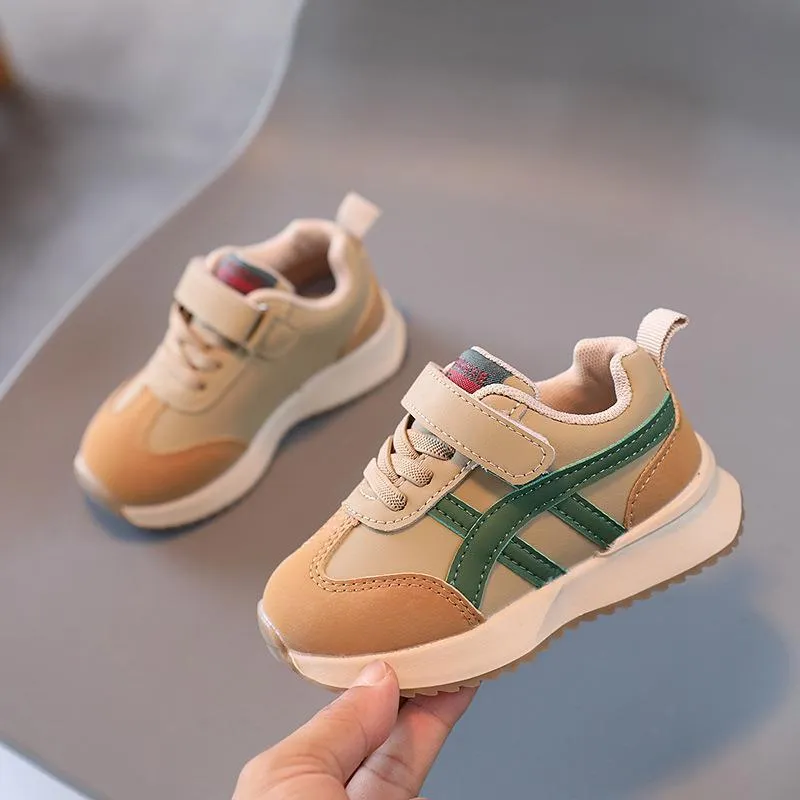Children's solid-colour sneakers with Velcro strap closure and rubber sole.