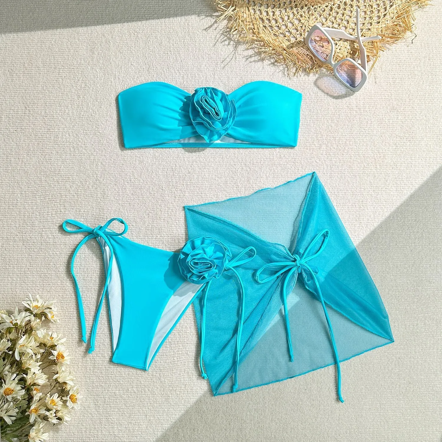 Women's blue tube top swimsuit with a large tied flower, matching pants and skirt.