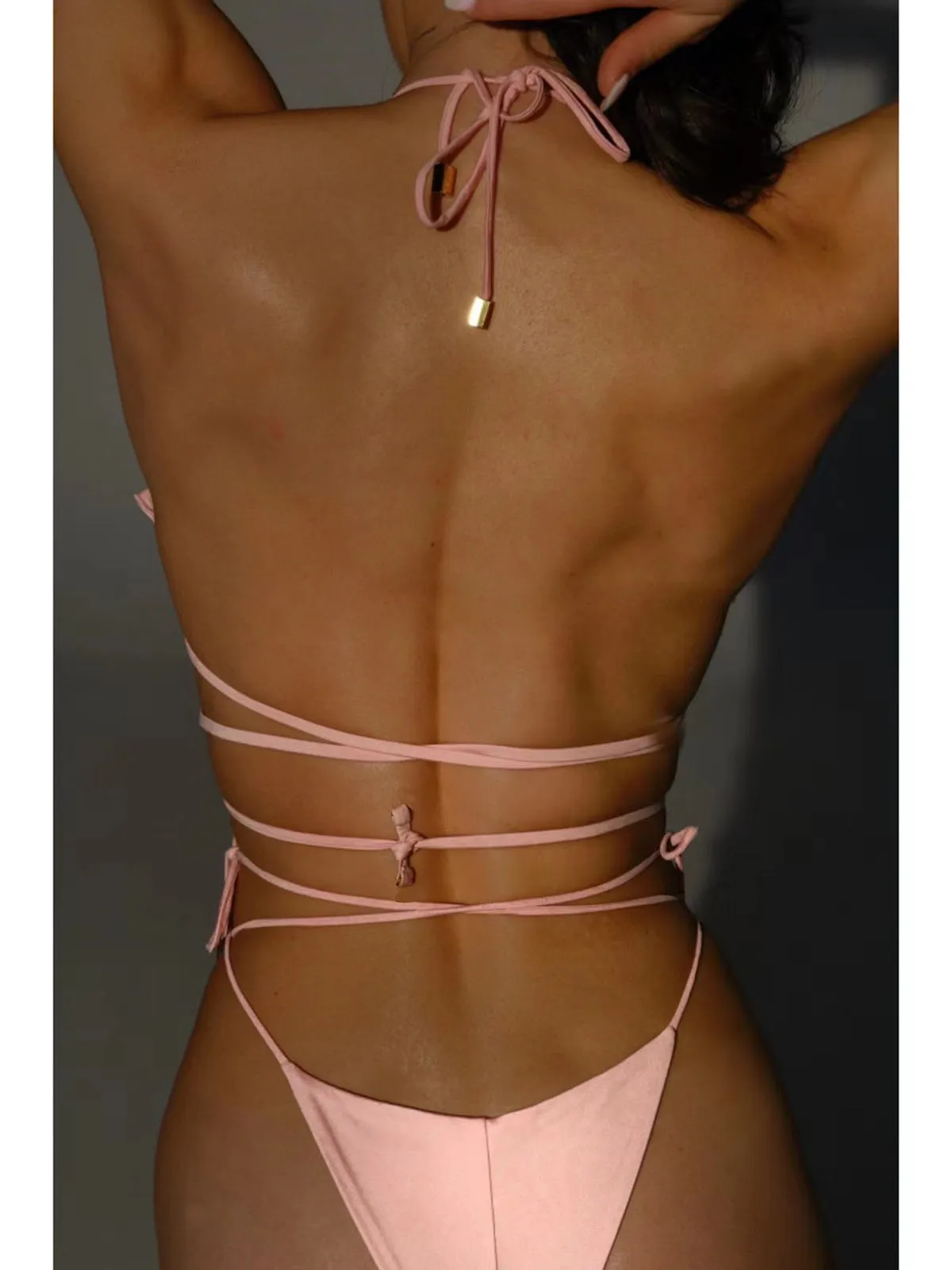 Pink halter lace-up three-dimensional flower bikini set on female model, backless brief style for swimming