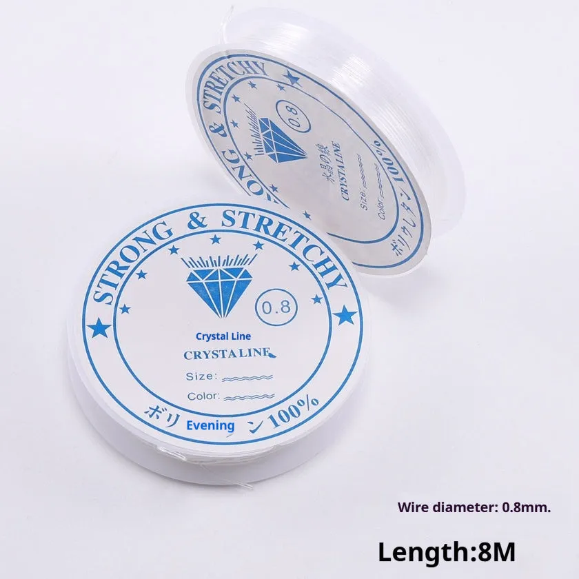 Spool of transparent white elastic cord for jewellery making on a craft table.