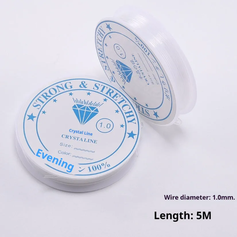 Spool of transparent white elastic cord for jewellery making on a craft table.