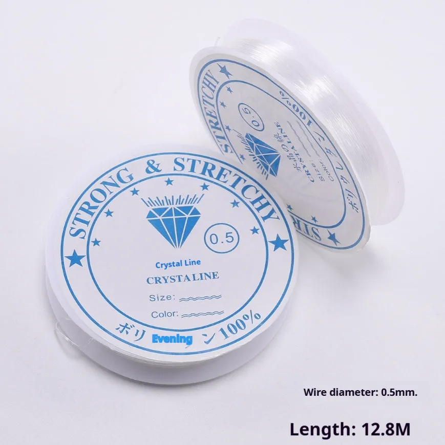 Spool of transparent white elastic cord for jewellery making on a craft table.