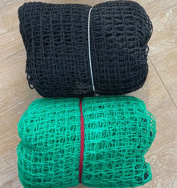 Polyethylene golf practice net in black on grass, with training balls visible