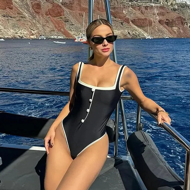 Black and white colour matching one-piece swimsuit with classic style belly coverage, backless design