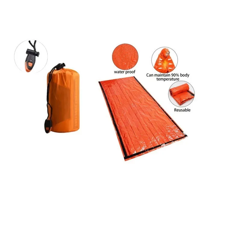 Orange aluminium foil emergency sleeping bag with drawstring bag and whistle on ground