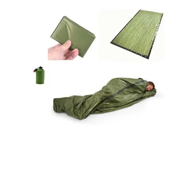 Orange aluminium foil emergency sleeping bag with drawstring bag and whistle on ground