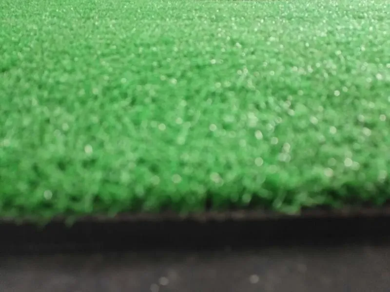 Green golf swing practice mat made of rubber and nylon, 15mm thick, on a driving range surface