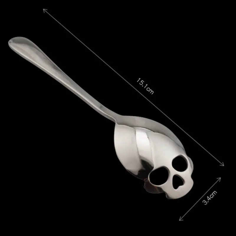 Stainless steel skull-shaped coffee mixing spoon on a dark surface