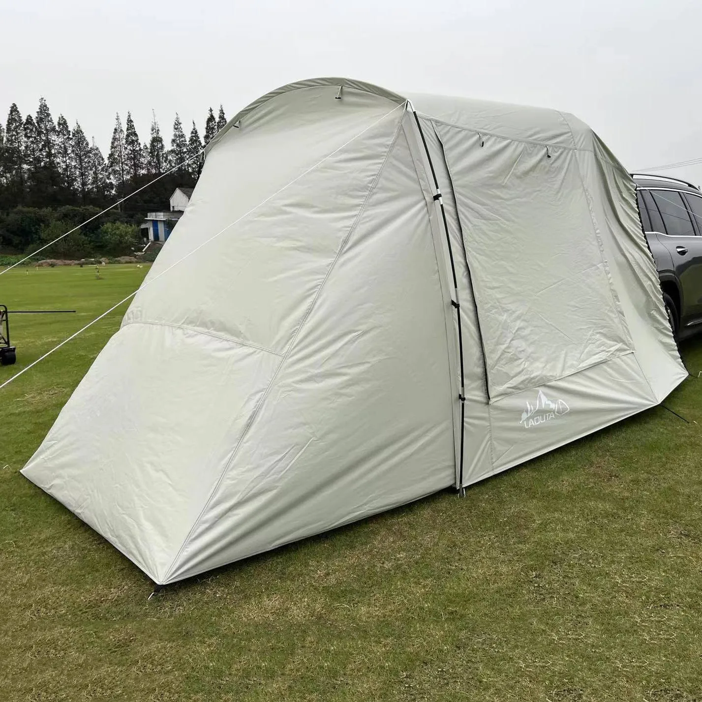 Car tail extension tent set up at a campsite with rear access, showing 190T silver-coated anti-UV fabric and screen windows.