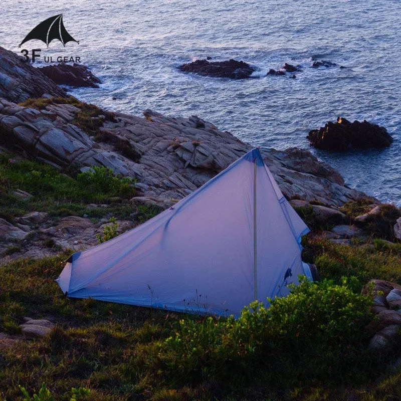 Silicon coated outdoor camping pyramid tent in green pitched on grass showing fly and aluminium pole