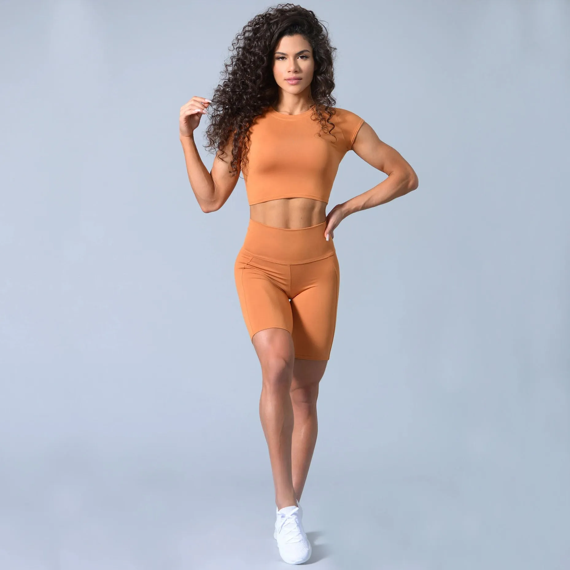 Cotton blended yoga sports suit with round neck, short sleeves, and shorts in green colour, side view on model.